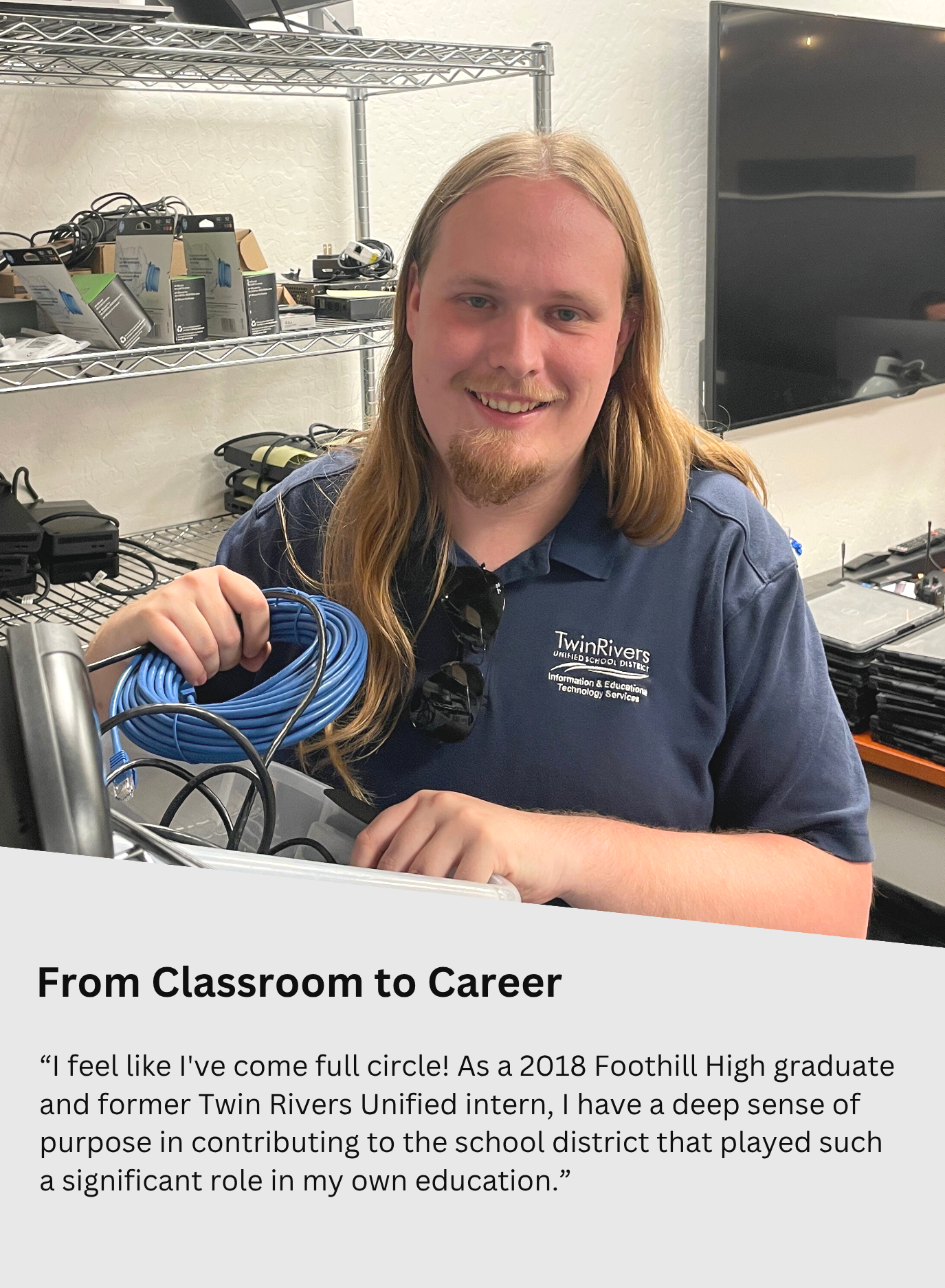 man smiling holding a rolled up ethernet cable