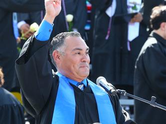 vice principal giving speech holding up his right arm and pointing to the sky.