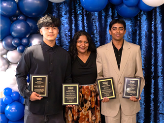 three high school students holding awards for student achievement