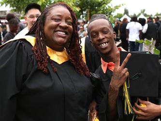 High school graduate smiling with staff member.