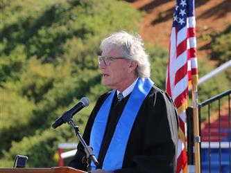high school principal giving a speech at graduation.