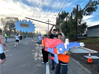 students holding signs up at a marathon race