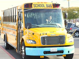 School bus driver in bus smiling.