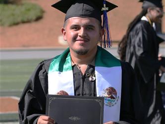 Adult Education graduate smiling brightly at graduation ceremony.