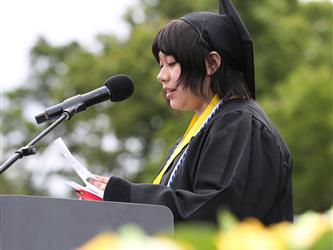 High school graduate giving a speech at graduation ceremony.
