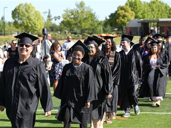 Adult Education graduates walking to the stage in procession.