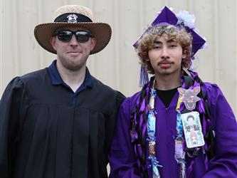 high school graduate with staff member.