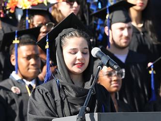 Adult Education graduate giving a speech at graduation ceremony.