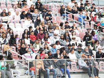people in stadium stands at a graduation ceremony.