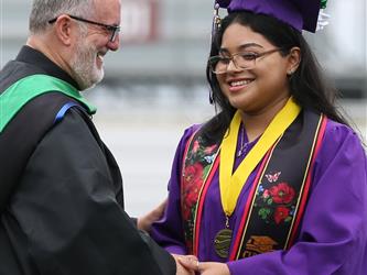 high school graduate being congratulated by principal. 