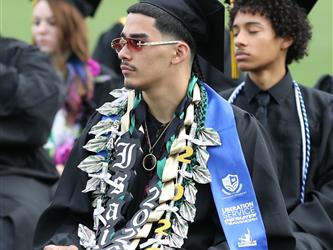 High school graduate sitting in chair.