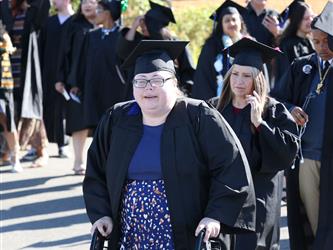 Adult Education graduates walking to the stage in procession.