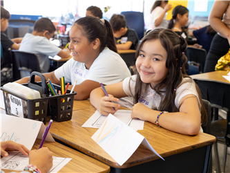 student at her desk smiling
