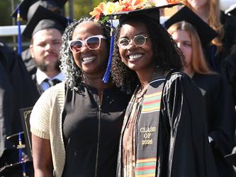 Adult Education principal  and graduating student posing for a photo at graduation ceremony.