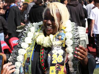 high school graduate with lots of leis around her neck.
