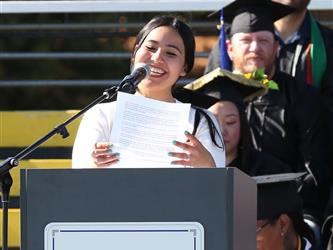 Adult Education staff member giving speech at graduation ceremony.