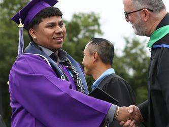 high school graduate shaking hands with principal.