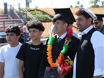 Adult Education graduate standing with family members.
