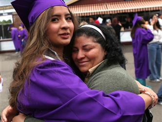 high school graduate hugging her mother.