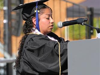 Adult Education graduate giving speech at graduation ceremony.