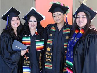 Four Adult Education graduate students smiling brightly.