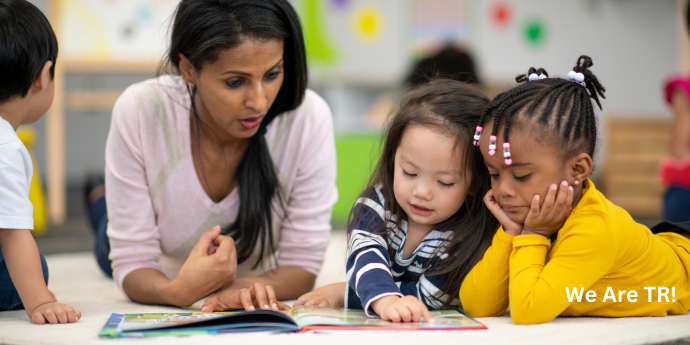 teacher with kids looking at a book