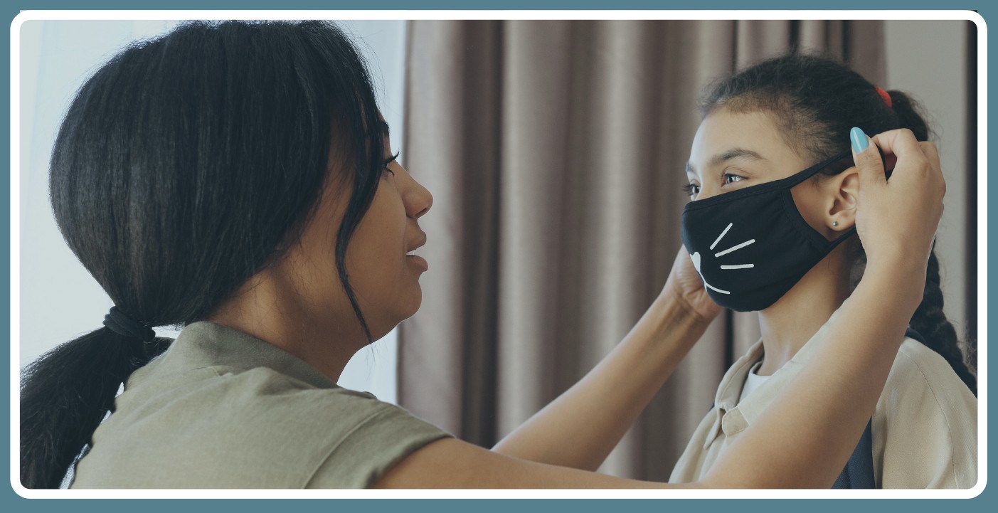 parent helping child with mask
