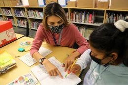 female teacher helping female student