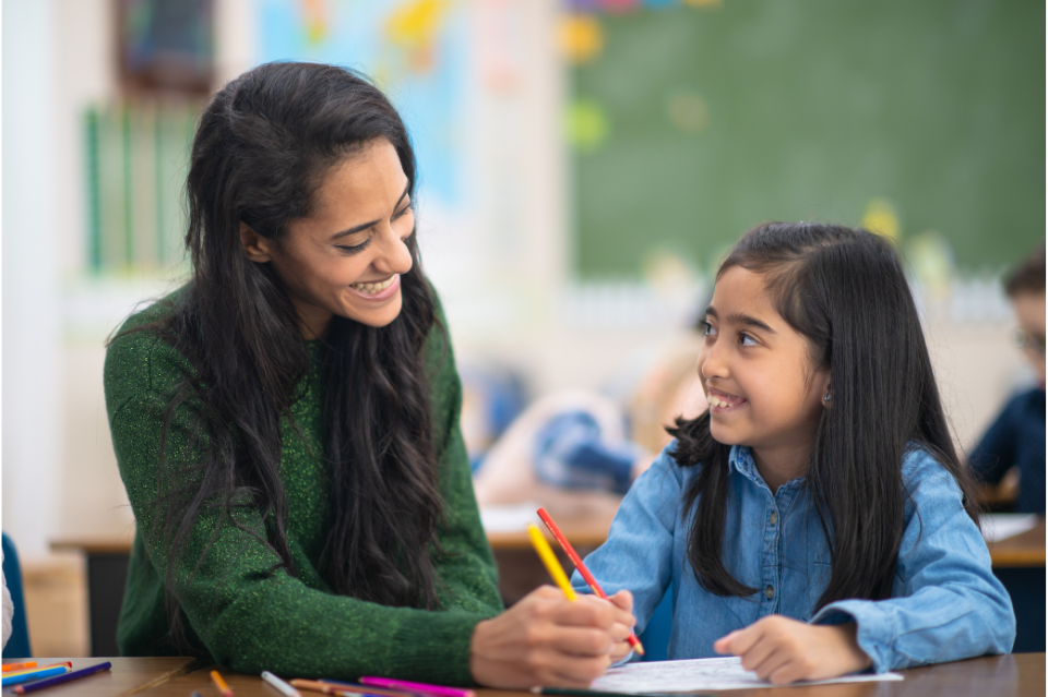 female teacher helping female student