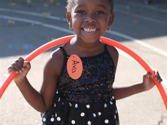 A little girl holding a hula hoop