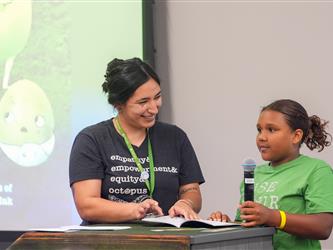 A student is reading a book with staff - Literacy Night
