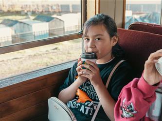 Westside after school program student looking at camera with cup