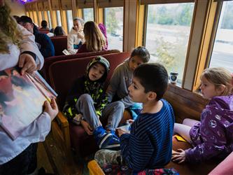 December 2025 - Polar Express staff presenting a book to students.