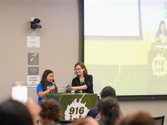 A student is reading a book with staff - Literacy Night