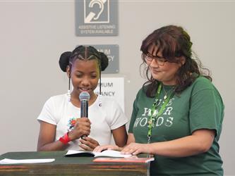 A student is reading a book with staff - Literacy Night
