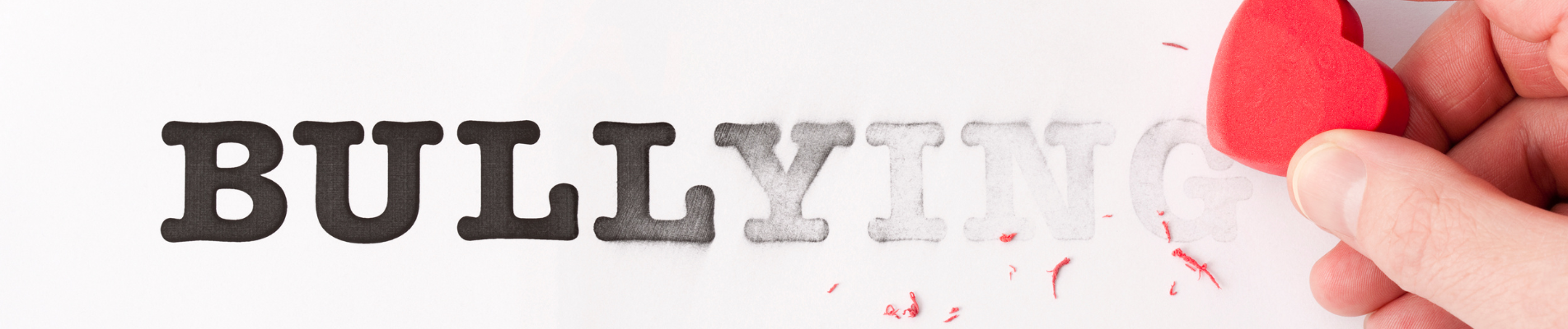 the word bullying being erased by a heart-shaped eraser